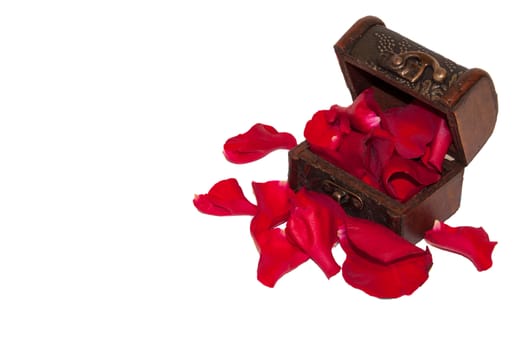 Red rose petals in the wooden chest.