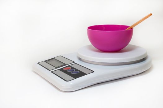 Plastic bowl on the digital kitchen scale