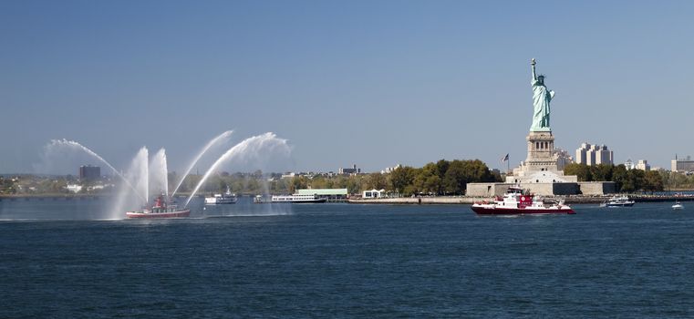 New York, USA, SEPT 27, 2014: The New York City Fire Department Boat practices maneuvers  in the Hudson River off New York City and Statue of Liberty