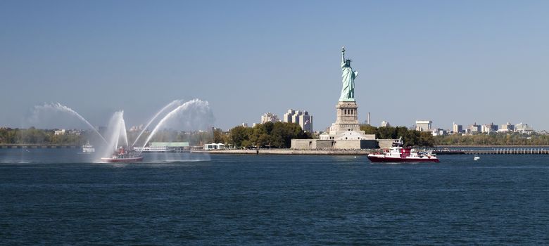 New York, USA, SEPT 27, 2014: The New York City Fire Department Boat practices maneuvers  in the Hudson River off New York City and Statue of Liberty