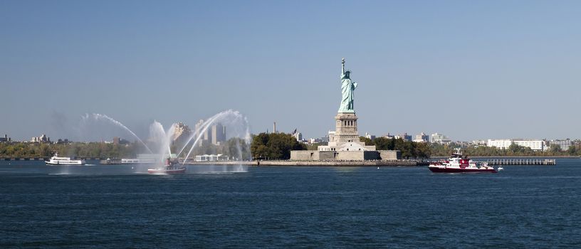 New York, USA, SEPT 27, 2014: The New York City Fire Department Boat practices maneuvers  in the Hudson River off New York City and Statue of Liberty