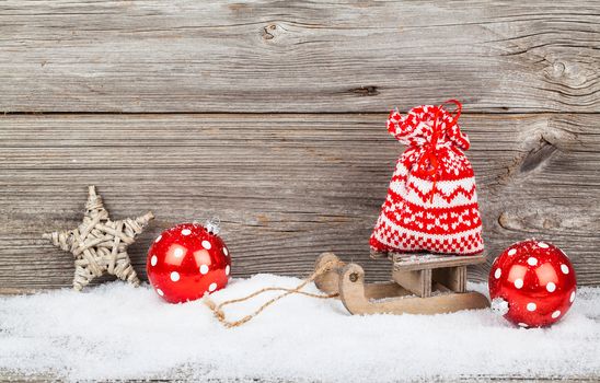 red bag on old rustic wooden sledge, over wooden background