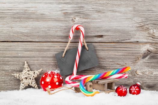 Christmas decoration with xmas canes, over wooden background