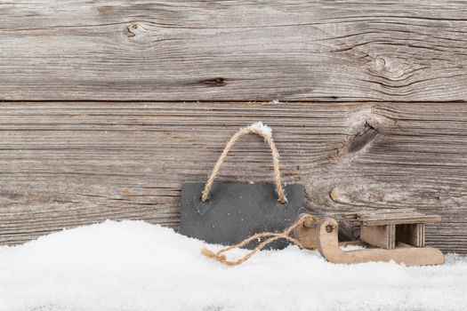 old rustic wooden sledge, over snow, wooden background