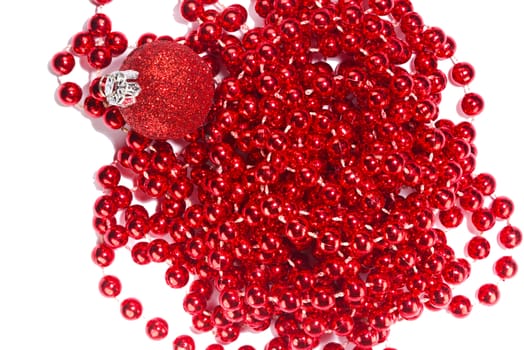 Photo shows a closeup of red Christmas beads and ornament on a white background.