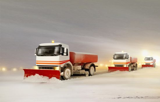 Snowplow Trucks Removing the Snow from the Highway during a Cold Snowstorm Winter Day