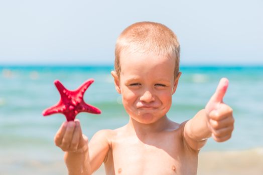 contented little boy on the sea with a star