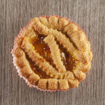 Small cake in close up over wooden background