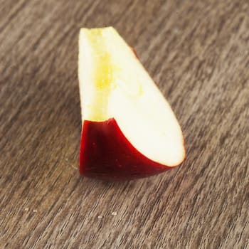 An apple slice over a wooden background