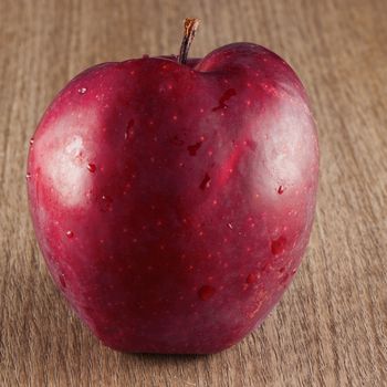 A red apple over a wooden background