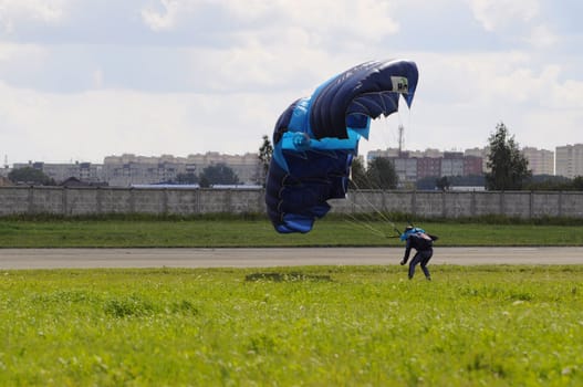 the parachutist lands on a multi-colored parachute