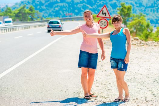 two friends Hitchhiking summer in the mountains