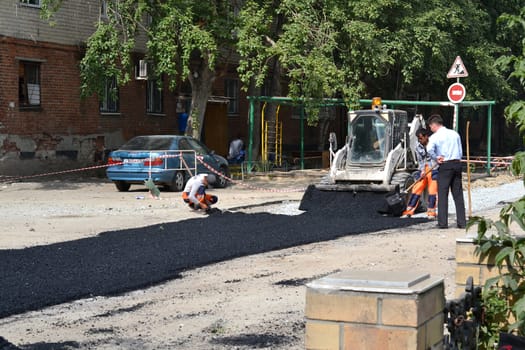 Road workers put asphalt on the road