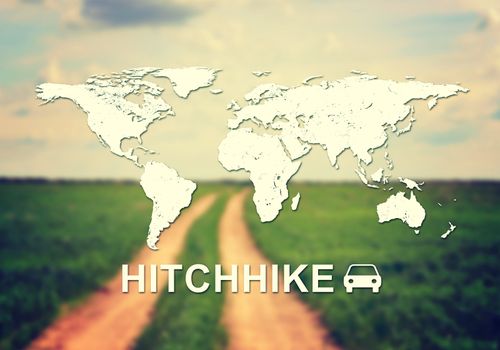 Contoured map of world continents with inscription Hitchhike and related symbol. Blurred photo of unsurfaced road in field as backdrop.