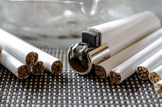 Ashtray and lighter on a dark background closeup