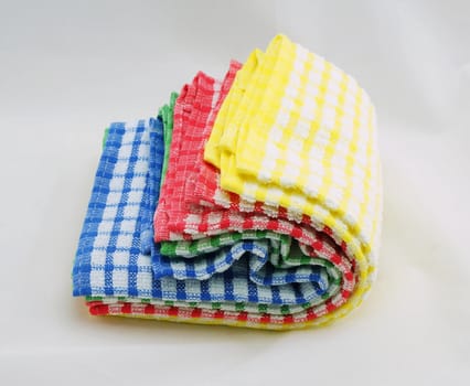 Napkin or kitchen towel, several piece stacked into piles on a white background.                               