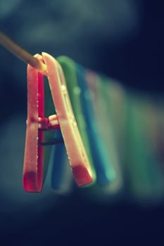 Colorful clothes pegs hanging in wire