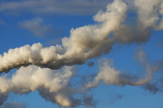 Photo of industrial smoke on a blue sky. Illustration of industrial pollution, environmental problems.
Taken in Riga, Latvia.