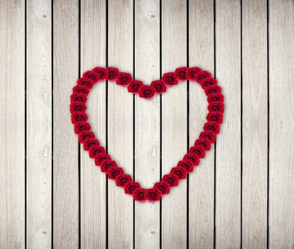 Heart Frame from red rose on wood