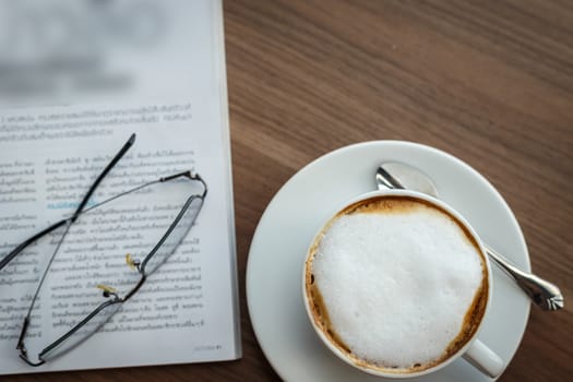 Coffee cup and book on the table
