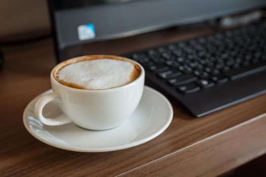 Coffee cup and computer on table