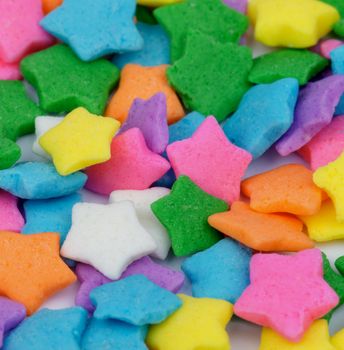 Background of Sugar Multi Colored Stars Dessert Toppings closeup. Focus on Centre