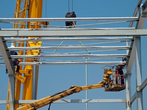 workers assembling construction frames on industrial hall