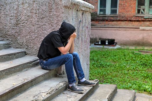 Sad Teenager on the landing steps of the Old House