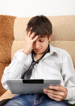 Stressed Teenager with Tablet Computer on the Sofa at the Home