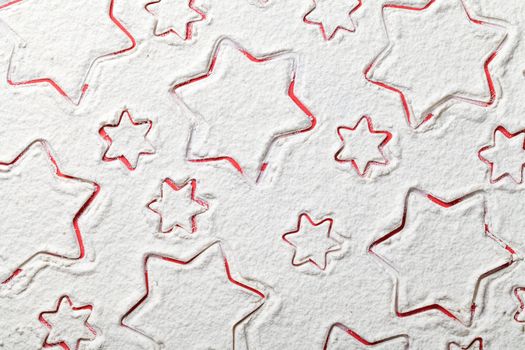 Christmas stars on flour background. White flour looks like snow. Top view