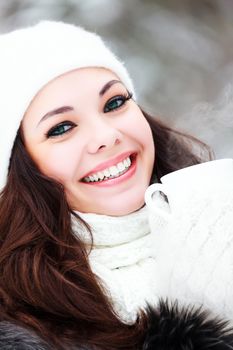 woman with a cup of hot tea posing outdoors