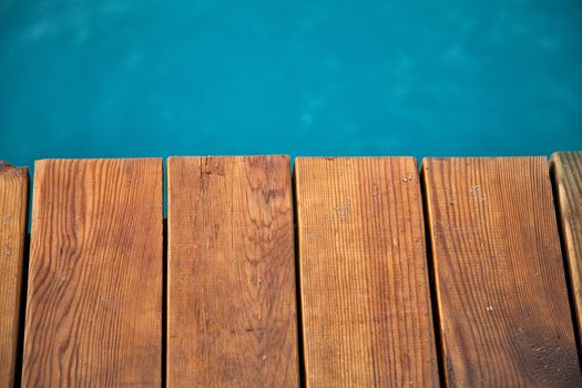 Closeup view of wooden pier with blue sea backdrop
