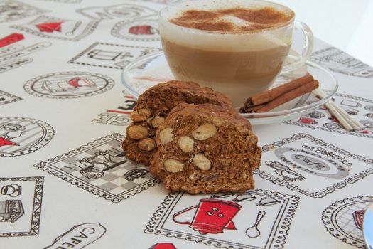 Italian biscuits with almonds- cantuccini. A cup of cappuccino in the background