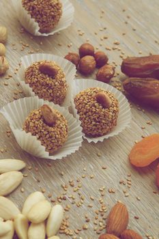 Homemade diet truffles with dried fruits and nut on wooden surface. Vintage style photo