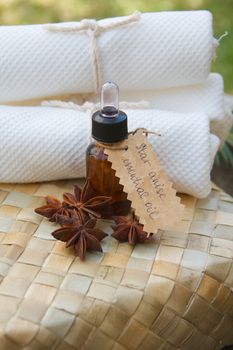 A bottle of star anise essential oil on the woven surface