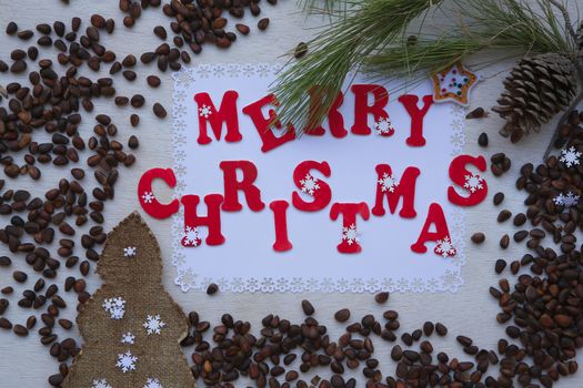 Christmas cedar nut  background on a white wooden surface with inscription: "Merry Christmas"