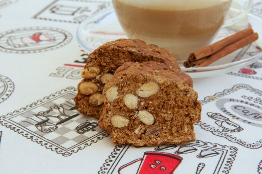 Italian biscuits with almonds- cantuccini. A cup of cappuccino in the background. Close up