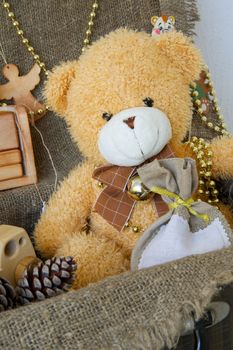 Christmas teddy bear in an old case with decorative items for a festive season