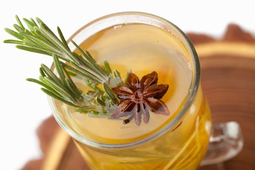 Traditional winter sweet hot alcohol drinks mulled white rum with orange, spices, cinnamon, rosemary, anise served on wooden board