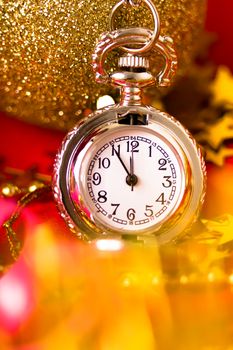 Christmas card. Silver vintage pocket watch on a red background with golden decorations