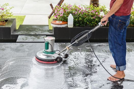 Thai people cleaning black granite floor with machine and chemical