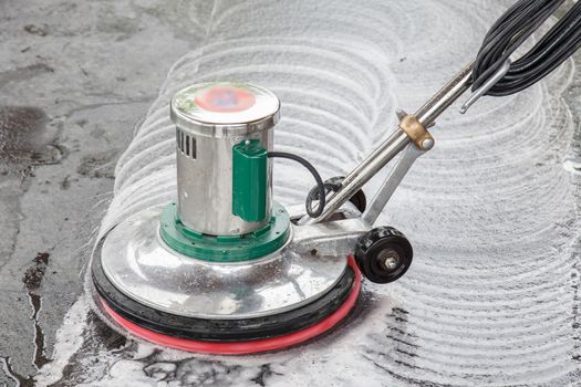 Thai people cleaning black granite floor with machine and chemical
