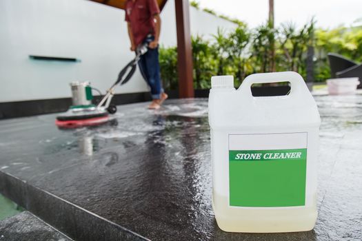 Thai people cleaning black granite floor with machine and chemical