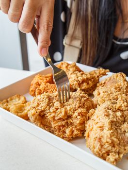 Hand holding Fried chicken and eating in the restaurant