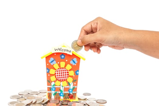 Hand holding coin and put in piggy bank isolated on white background