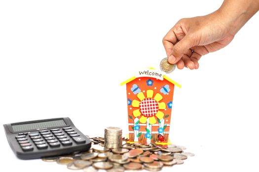 Hand holding coin and put in piggy bank isolated on white background