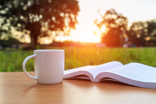 Coffee cup and book on the table in the morning