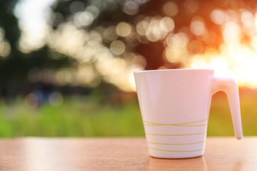 Coffee cup on the table in sunset time