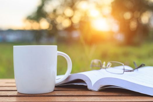 Coffee cup and book on the table in the morning