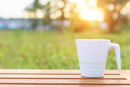 Coffee cup on the table in sunset time